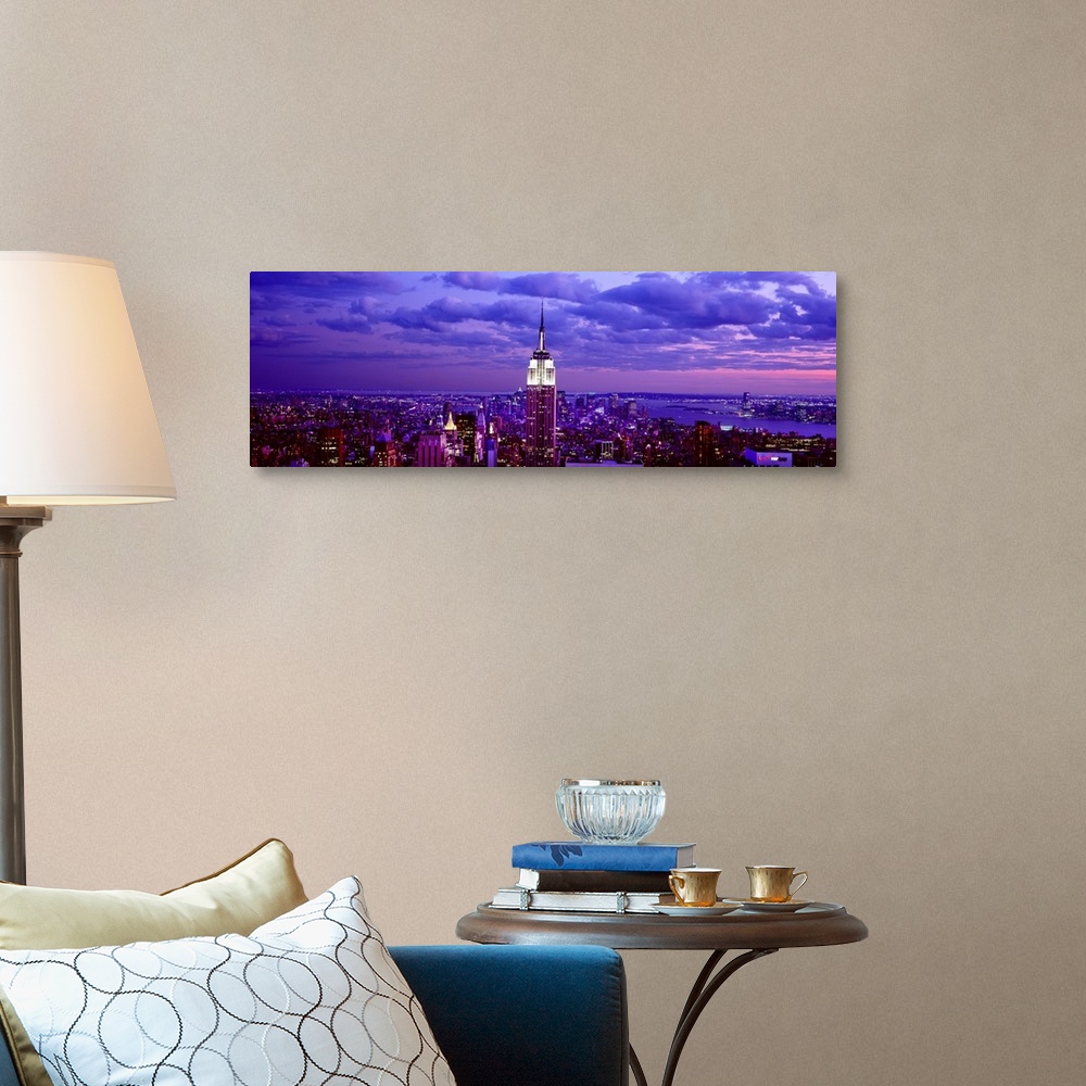 A traditional room featuring This is a large aerial photograph taken of NYC at dusk with all of the buildings lit and the empi...
