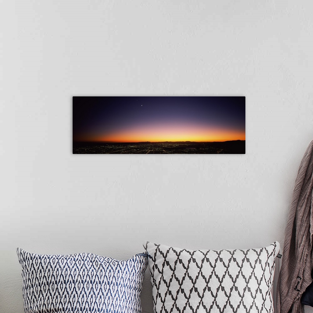A bohemian room featuring An aerial photograph taken of Los Angeles at night with the sun just setting below the horizon.