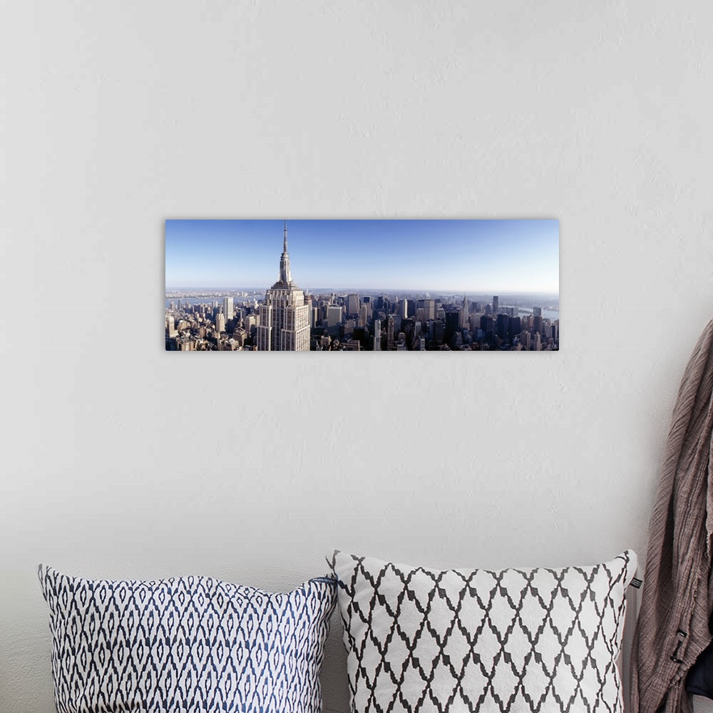 A bohemian room featuring A high angle photograph of the NYC skyline with the Empire State building in the foreground tower...