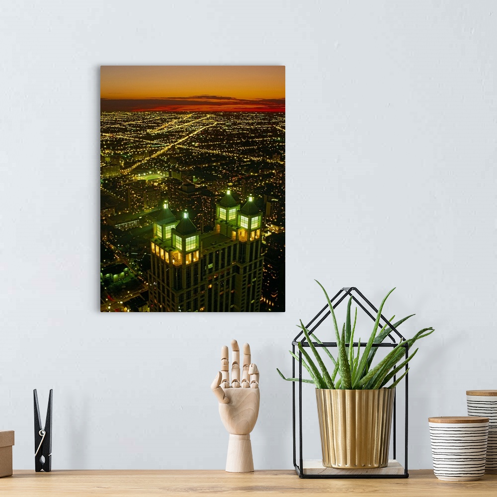 A bohemian room featuring Canvas photo art of a cityscape seen from above lit up at sunset.