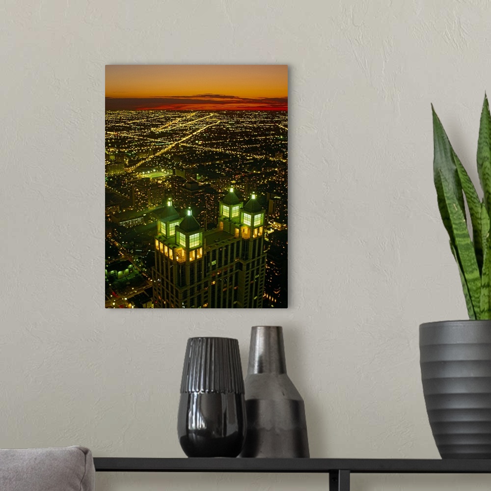 A modern room featuring Canvas photo art of a cityscape seen from above lit up at sunset.