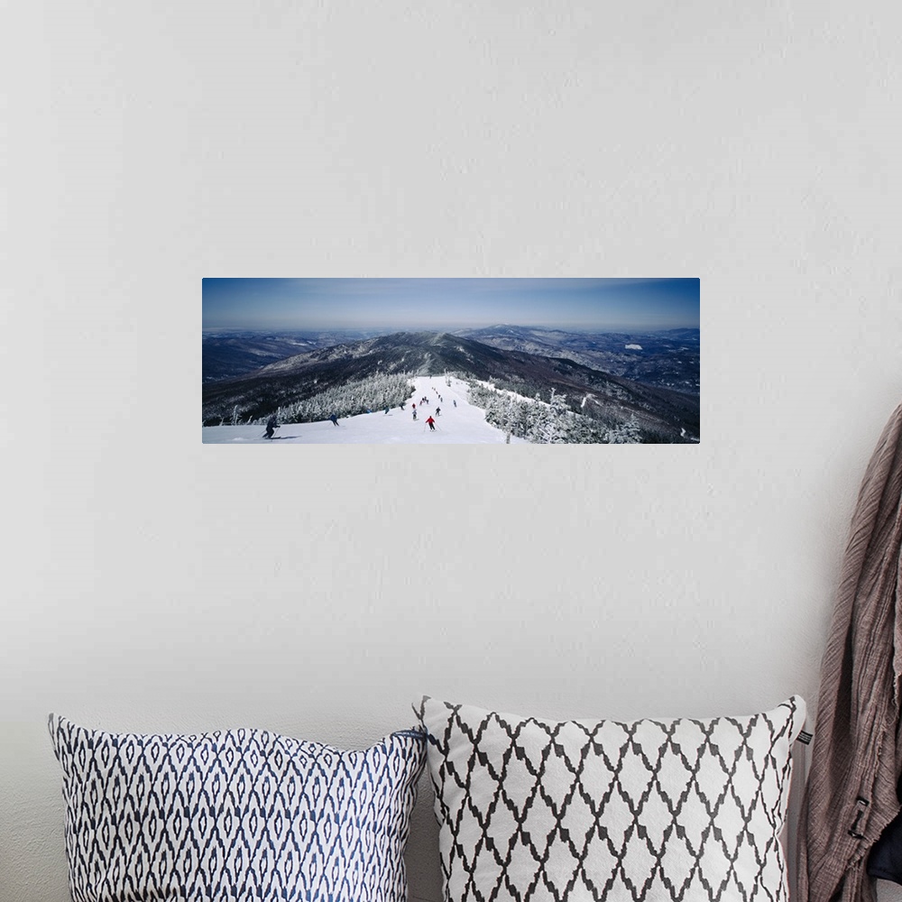 A bohemian room featuring This is a panoramic photograph of skiers heading down a mountain covered with powdery snow in the...