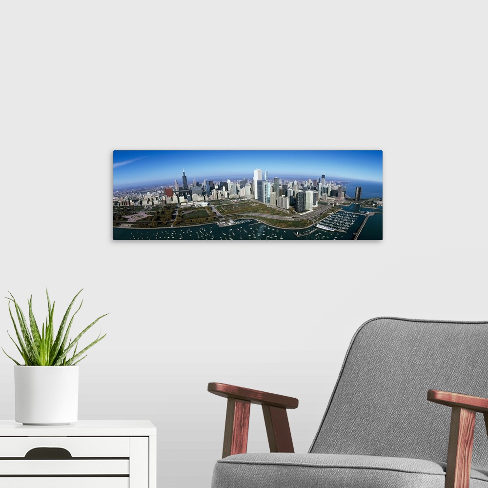 A modern room featuring Panoramic photo canvas art of the Chicago cityscape with boats in the harbor seen from above.