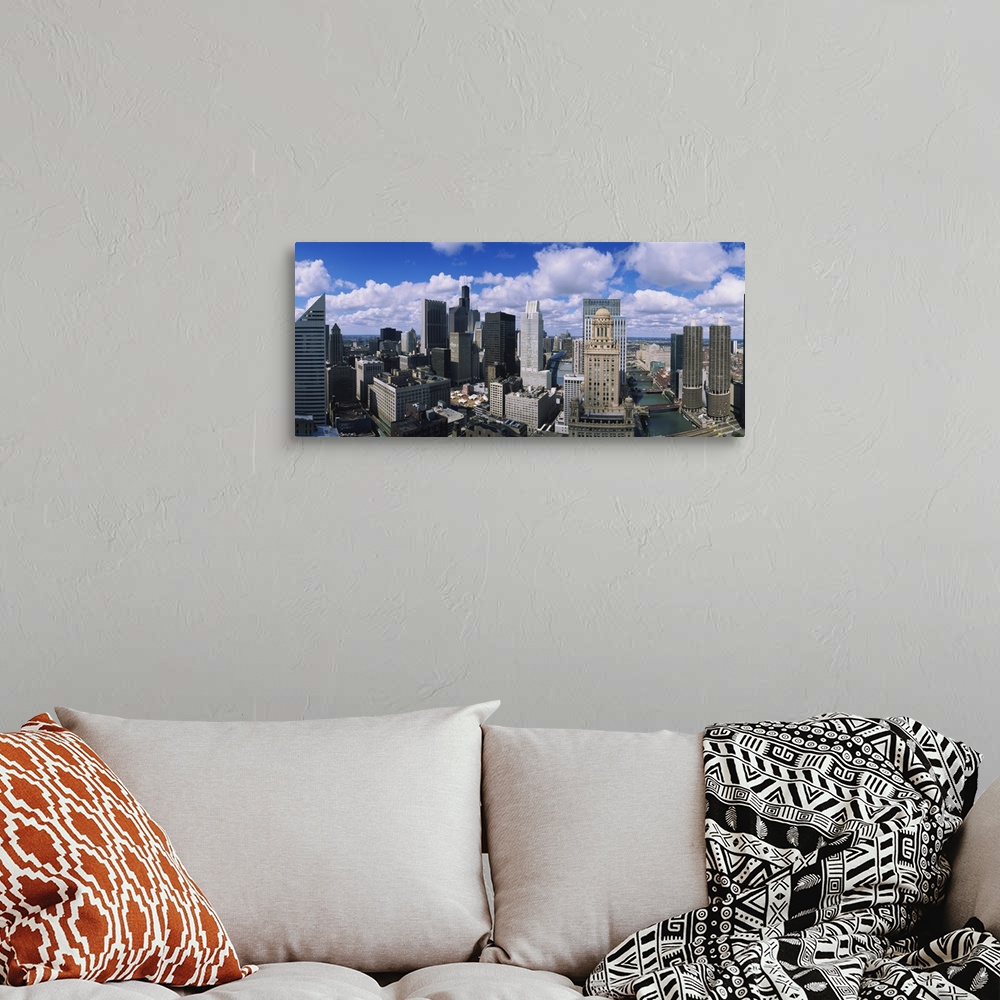 A bohemian room featuring Puffy white clouds over a wide array of skyscrapers in the industrious Midwestern city.