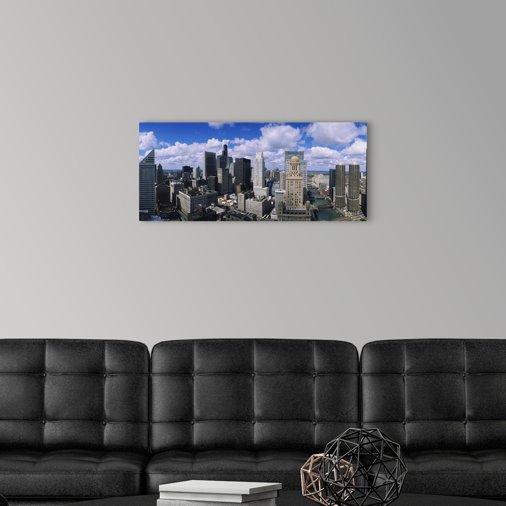 A modern room featuring Puffy white clouds over a wide array of skyscrapers in the industrious Midwestern city.