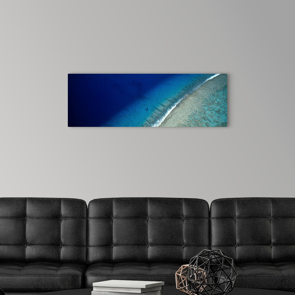 A modern room featuring Large panoramic wall hanging photograph depicting an aerial view of a sand beach on Teti'aroa Isl...