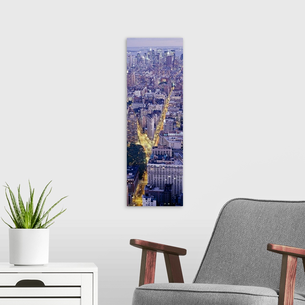 A modern room featuring Tall panoramic piece of an aerial photograph taken of the skyline in Manhattan during dusk with t...
