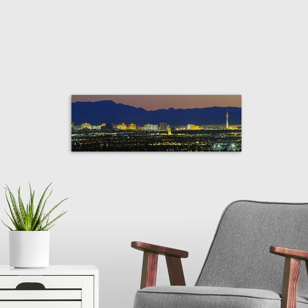 A modern room featuring Panorama of Las Vegas skyline with the Rocky Mountains in the background at night.