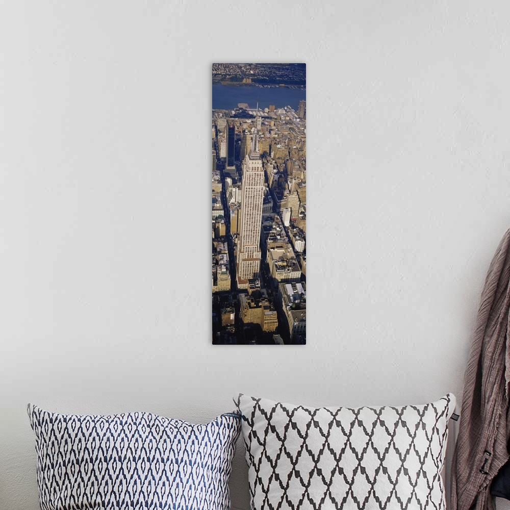 A bohemian room featuring A long vertical picture taken from above the Empire State building which towers over the city sur...