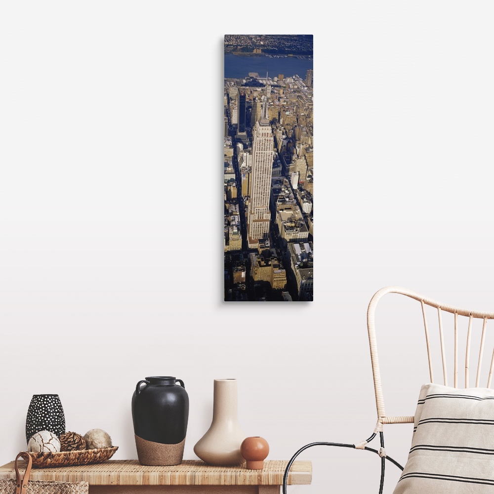 A farmhouse room featuring A long vertical picture taken from above the Empire State building which towers over the city sur...