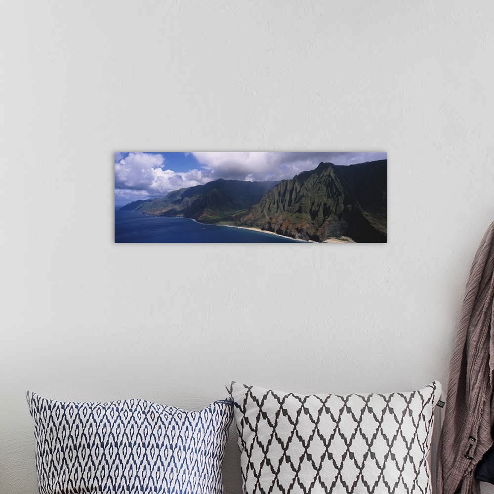 A bohemian room featuring Panoramic photograph of mountainous shoreline under a cloudy sky.