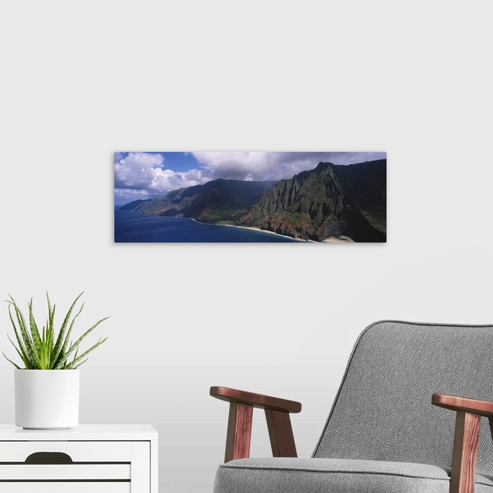 A modern room featuring Panoramic photograph of mountainous shoreline under a cloudy sky.
