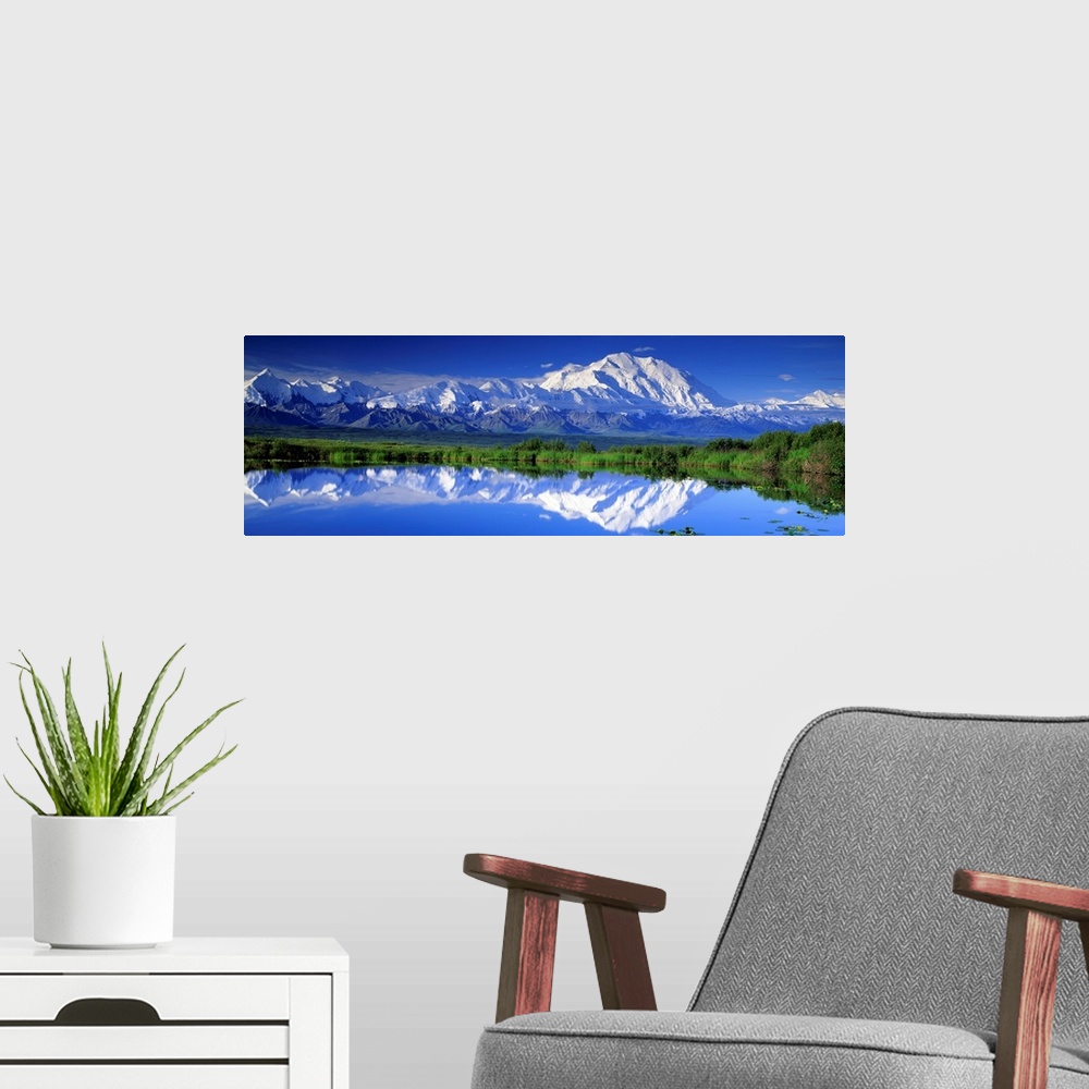A modern room featuring Panoramic view of snowcapped mountains and Mt. McKinley reflecting in still waters.