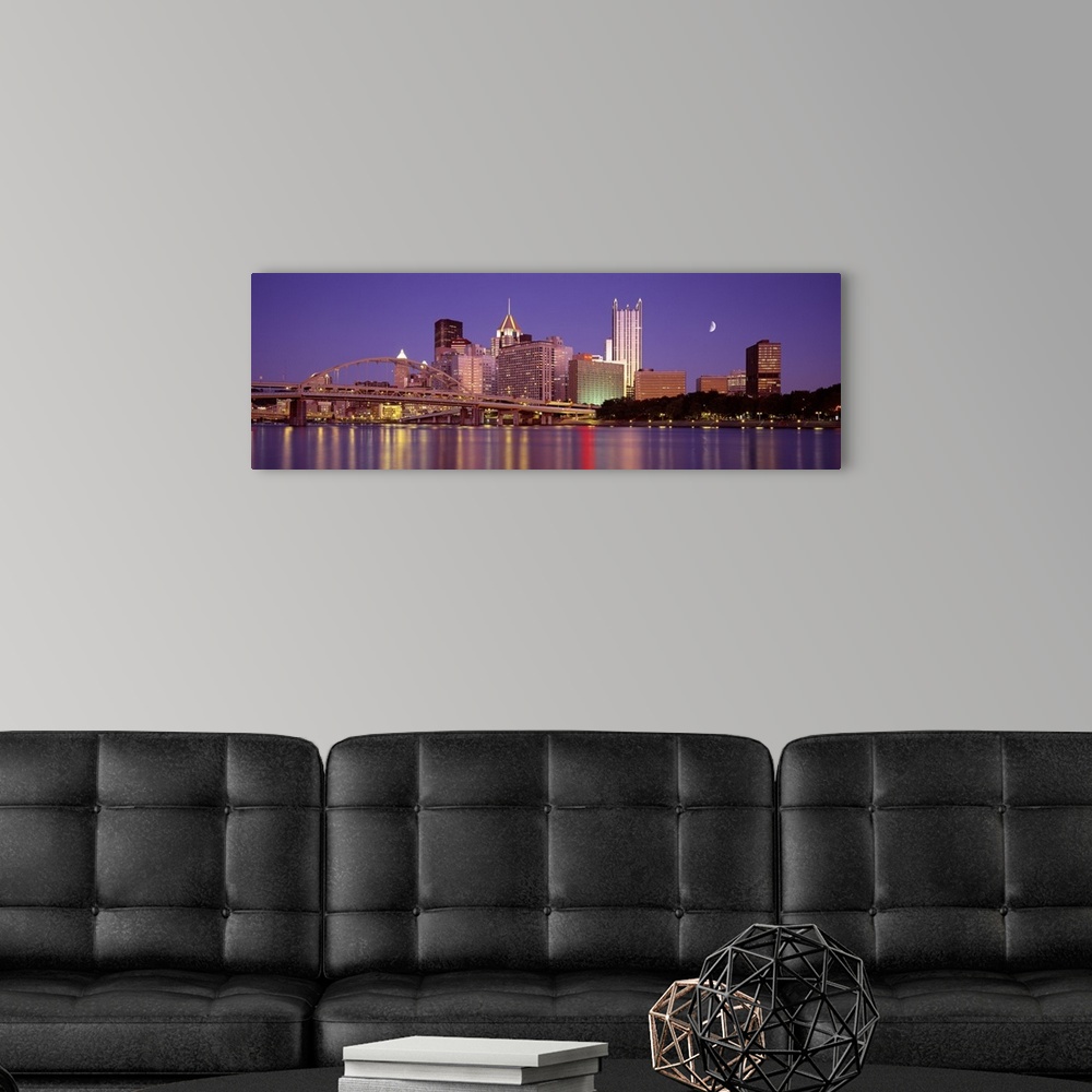 A modern room featuring Panoramic view of the bridge and city buildings in Pittsburgh, Pennsylvania, at night, with blurr...