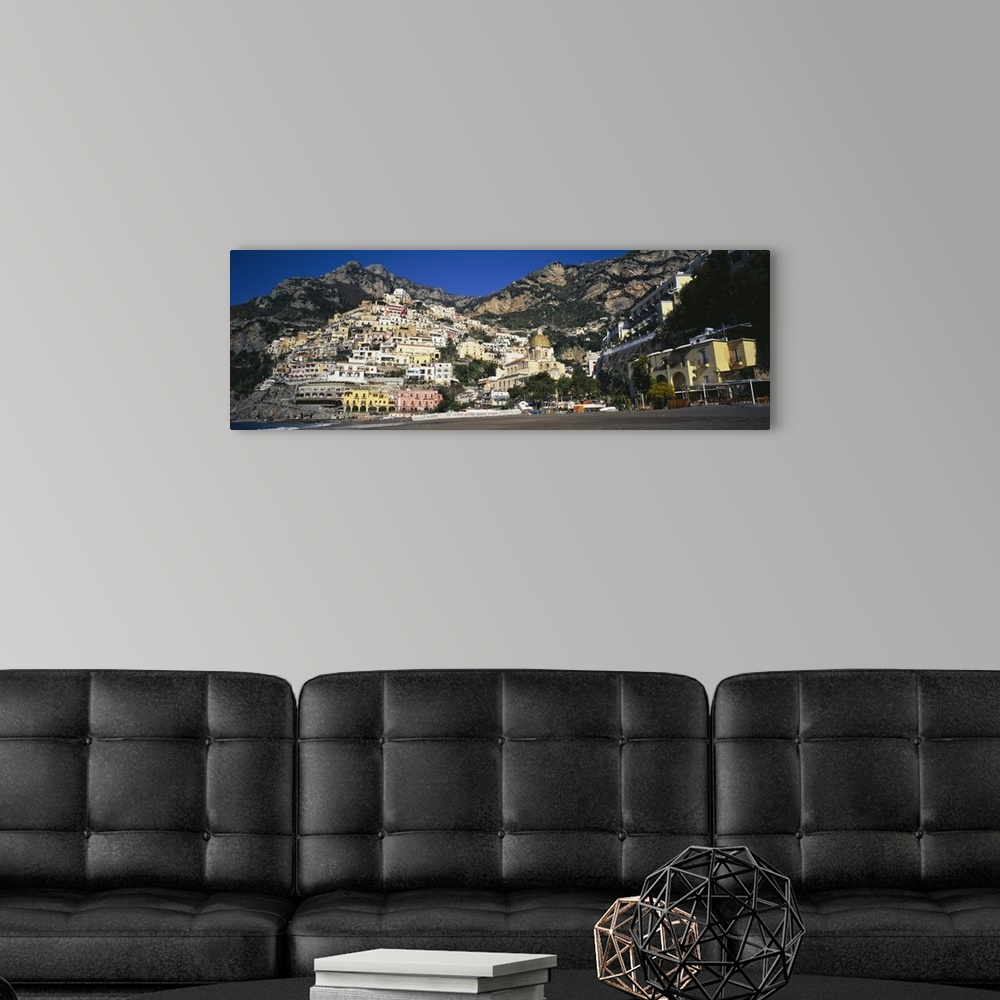 A modern room featuring View from below of the buildings stacked upon the hill off the Amalfi Coast in Positano, Italy.
