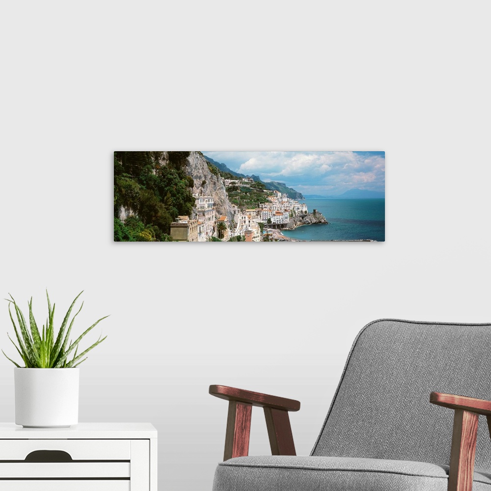 A modern room featuring Wide angle photograph taken of buildings that sit in the mountains and line the ocean coast in It...