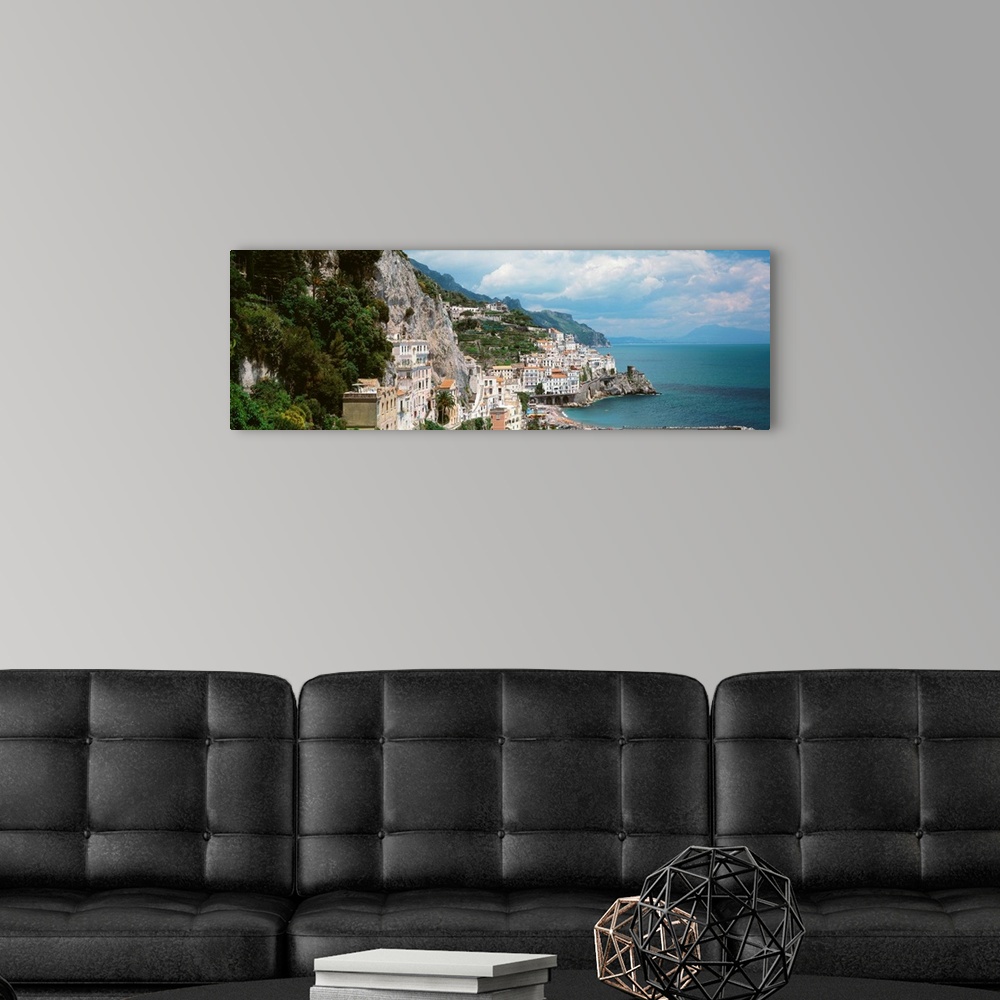 A modern room featuring Wide angle photograph taken of buildings that sit in the mountains and line the ocean coast in It...