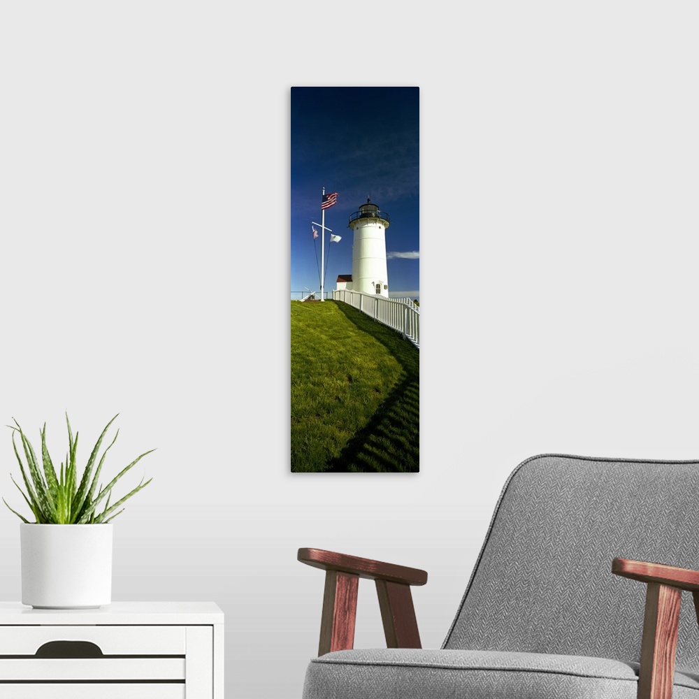 A modern room featuring Giant vertical photograph looking up a grassy hill along a fence toward Nobska Lighthouse next to...