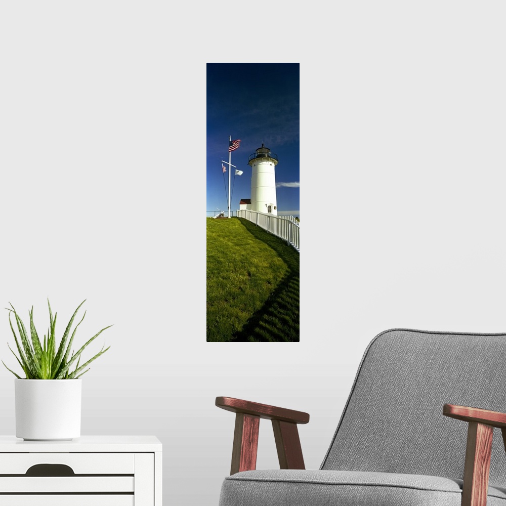 A modern room featuring Giant vertical photograph looking up a grassy hill along a fence toward Nobska Lighthouse next to...