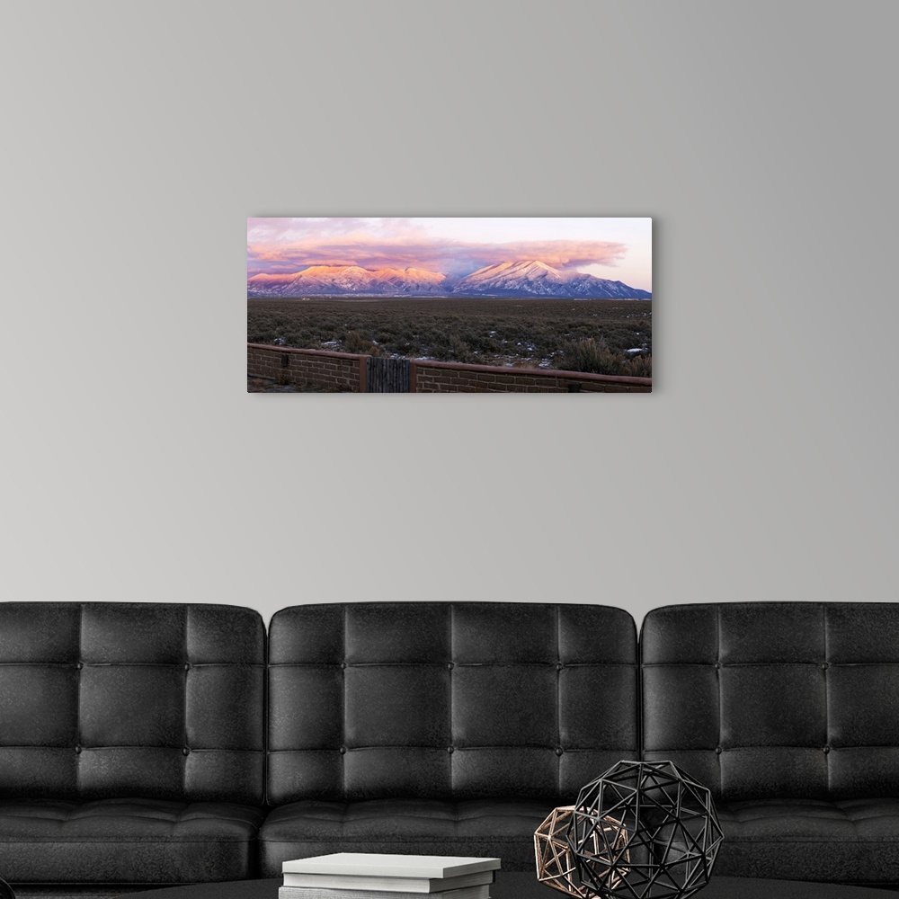 A modern room featuring Mountain range viewed from an adobe brick wall and Sangre De Cristo Mountains, New Mexico, USA.