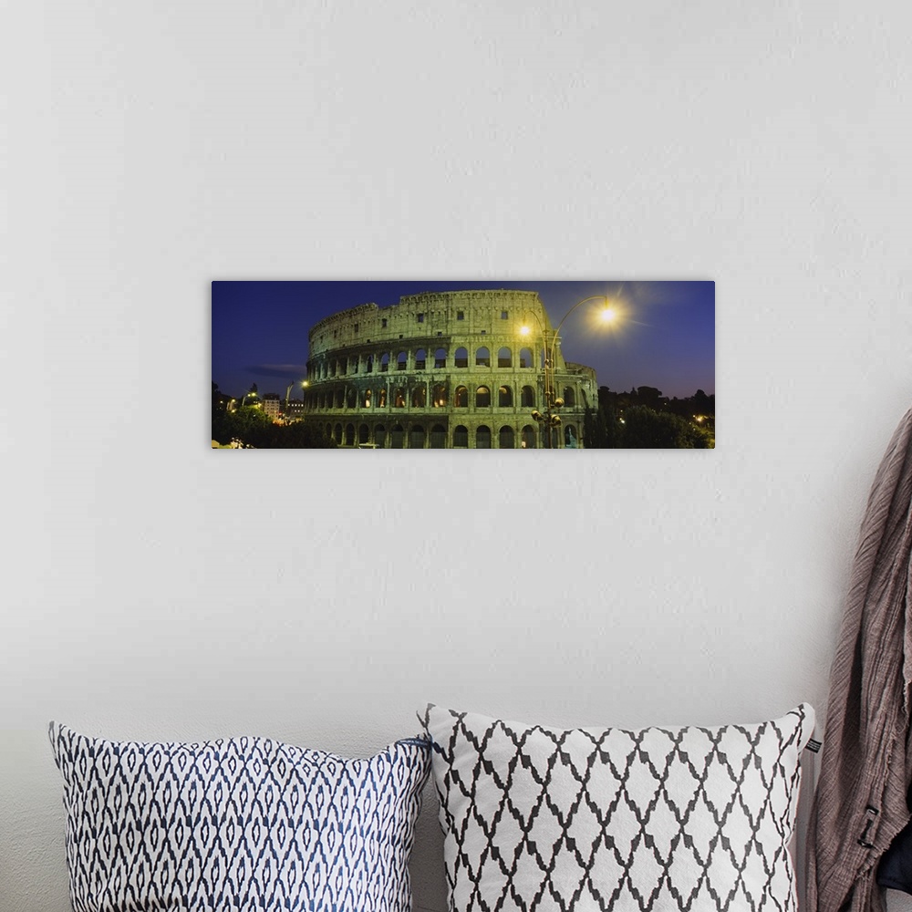 A bohemian room featuring A panorama of the Roman Colosseum at night, with emphasis on the facade.