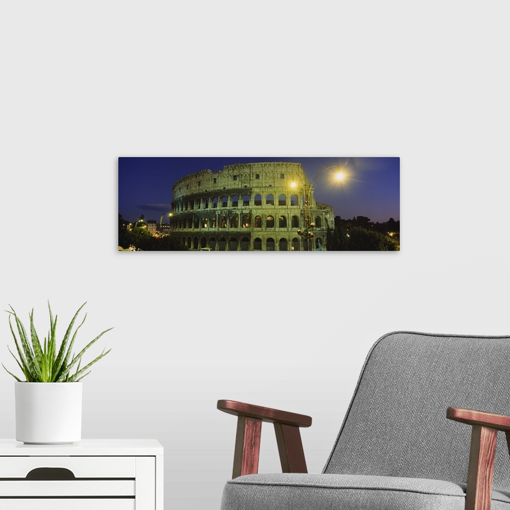 A modern room featuring A panorama of the Roman Colosseum at night, with emphasis on the facade.