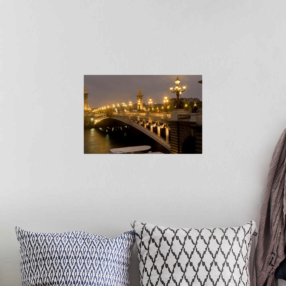 A bohemian room featuring Big photo on canvas of a bridge lit up going over a river in France.