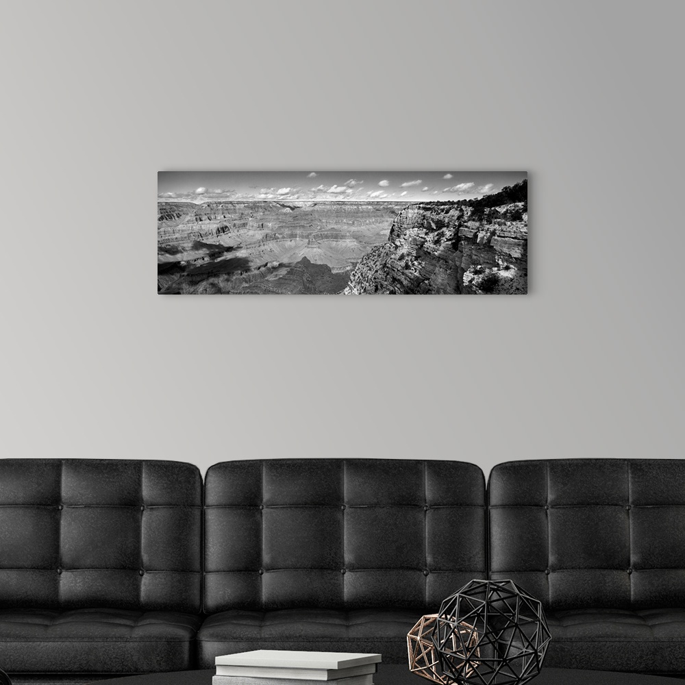 A modern room featuring Panoramic photo on canvas of a view of the Grand Canyon seen from the top of a cliff with puffy c...