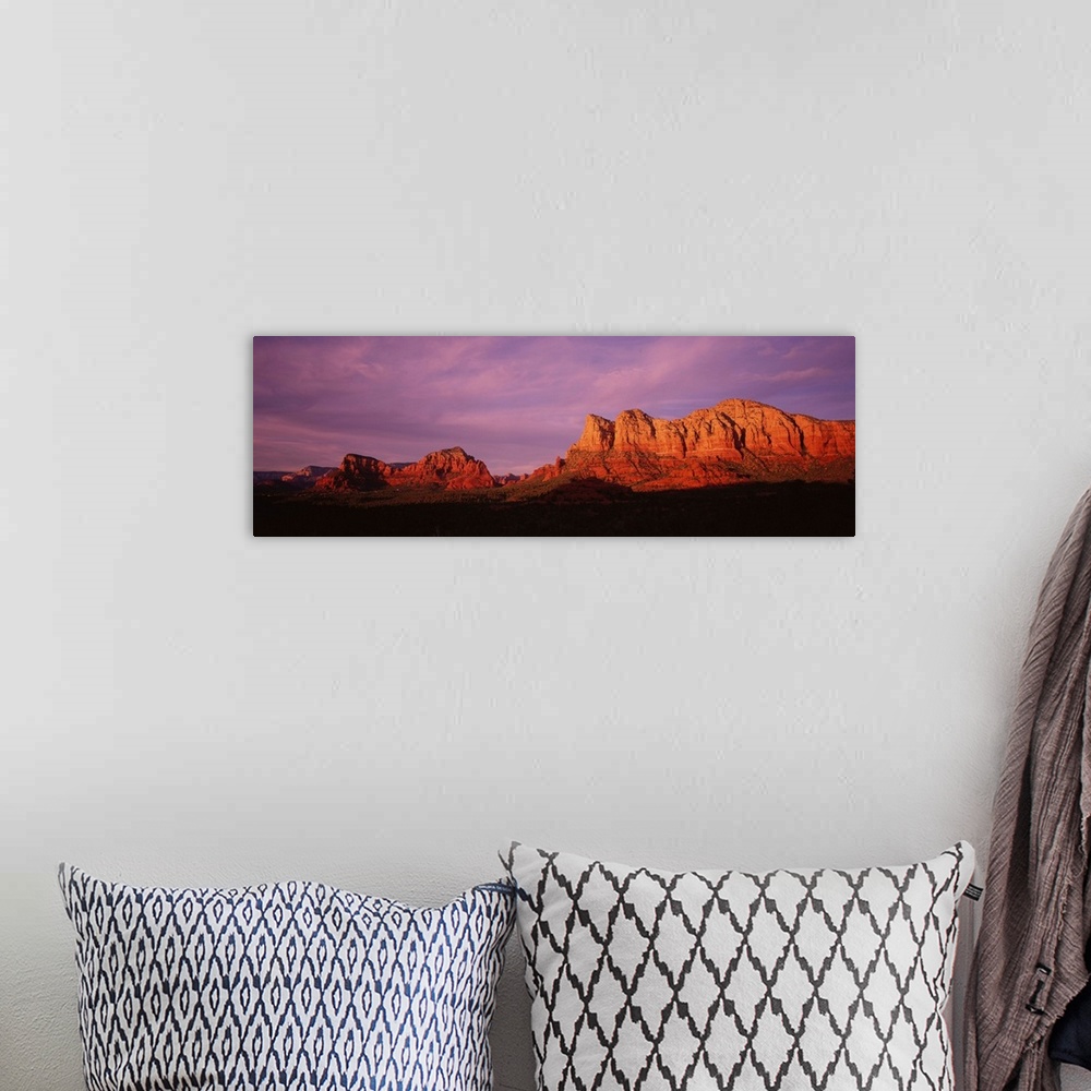 A bohemian room featuring This photograph is a panoramic wall hanging that captures the fading light illuminating the deser...