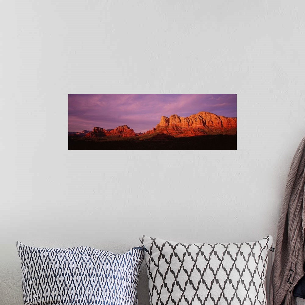 A bohemian room featuring This photograph is a panoramic wall hanging that captures the fading light illuminating the deser...