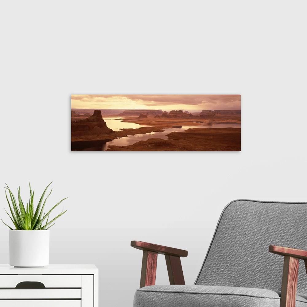 A modern room featuring Large panoramic photograph of the sun beginning to rise over Lake Powell and the red rock desert ...