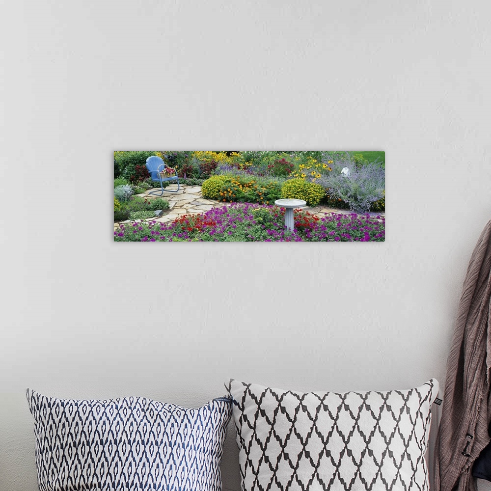 A bohemian room featuring Oversized, horizontal photograph of many types of vibrant flowers and green foliage in a flower g...
