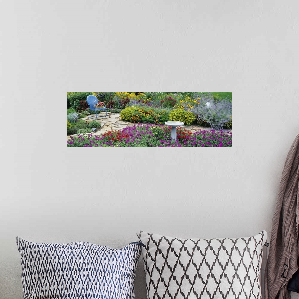 A bohemian room featuring Oversized, horizontal photograph of many types of vibrant flowers and green foliage in a flower g...