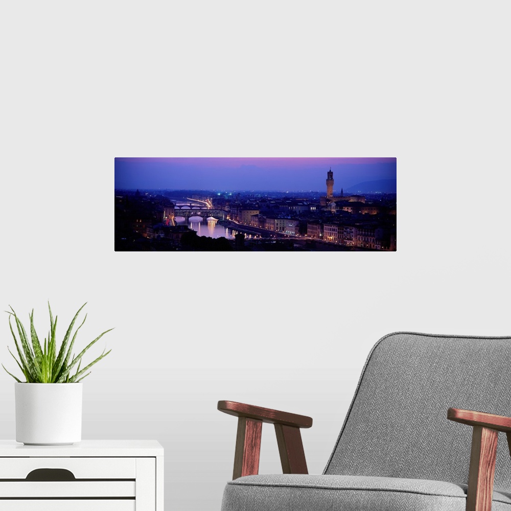 A modern room featuring Panoramic photograph of skyline at night with buildings lit up.