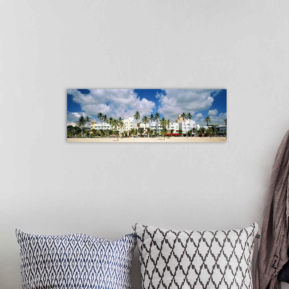 A bohemian room featuring Panoramic photograph of beachfront lined with historic motels and palm trees under a cloudy sky.
