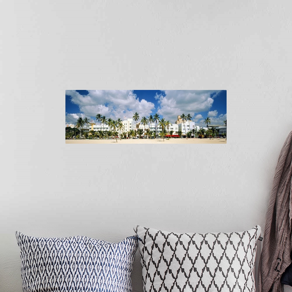 A bohemian room featuring Panoramic photograph of beachfront lined with historic motels and palm trees under a cloudy sky.