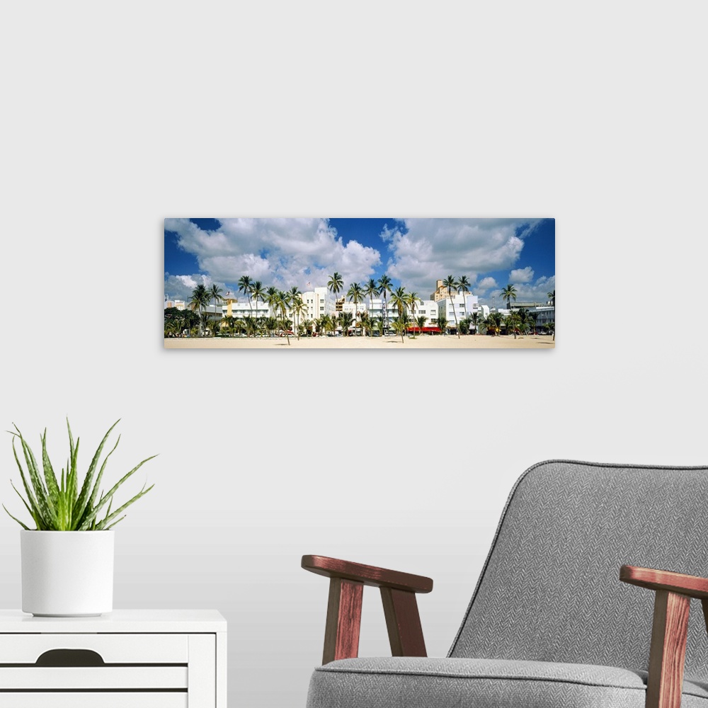 A modern room featuring Panoramic photograph of beachfront lined with historic motels and palm trees under a cloudy sky.
