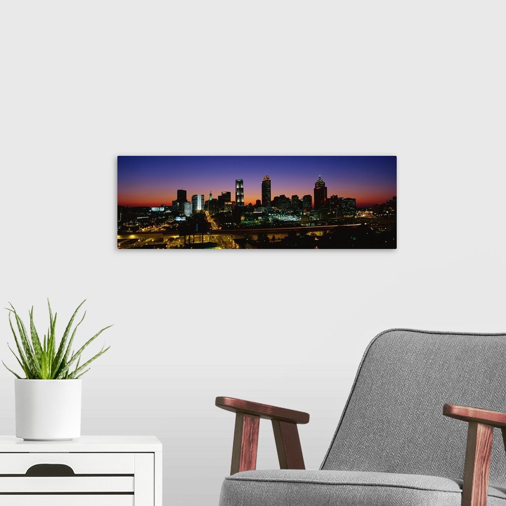 A modern room featuring Panoramic photograph at nighttime shows an aerial view overlooking the illuminated skyline and bu...