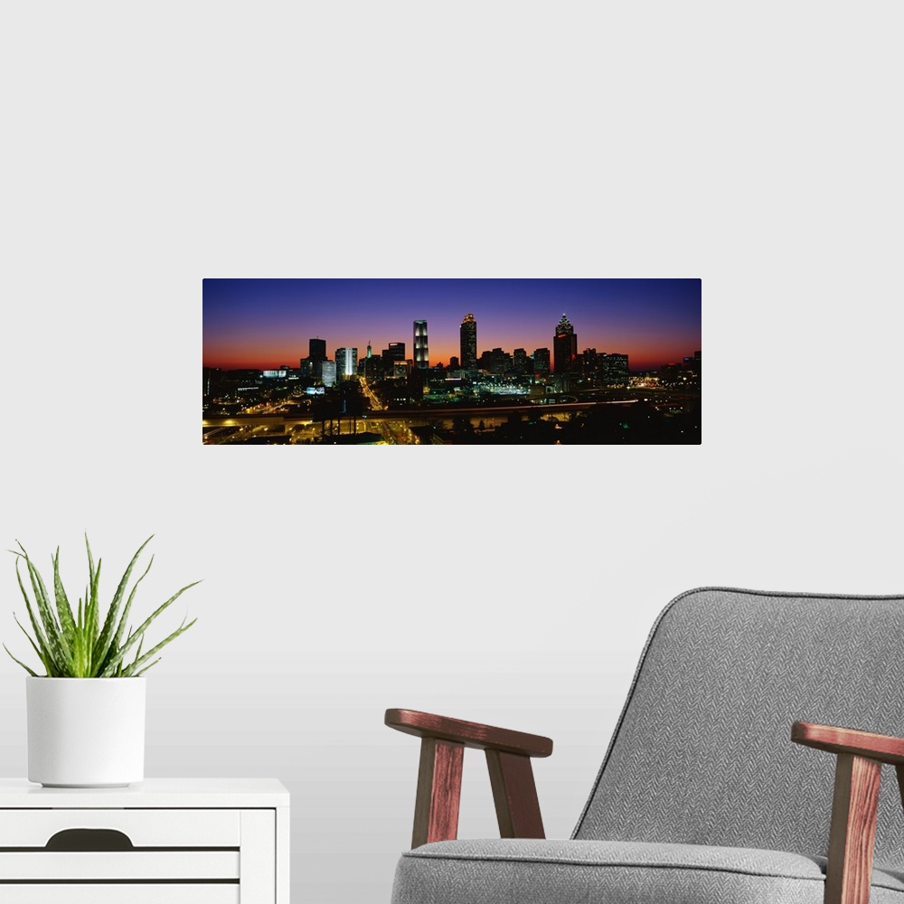 A modern room featuring Panoramic photograph at nighttime shows an aerial view overlooking the illuminated skyline and bu...