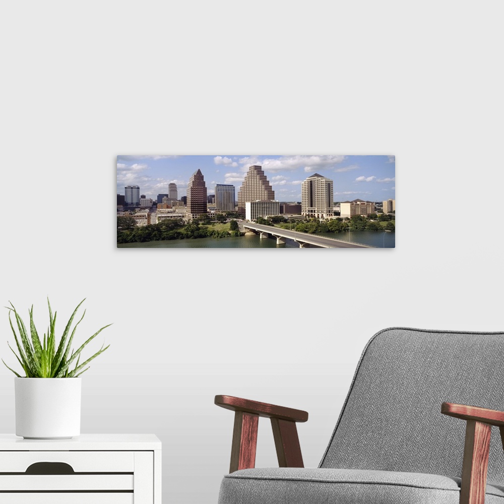 A modern room featuring Panoramic photograph of the Austin, Texas skyline beneath a blue sky with small fluffy clouds, th...