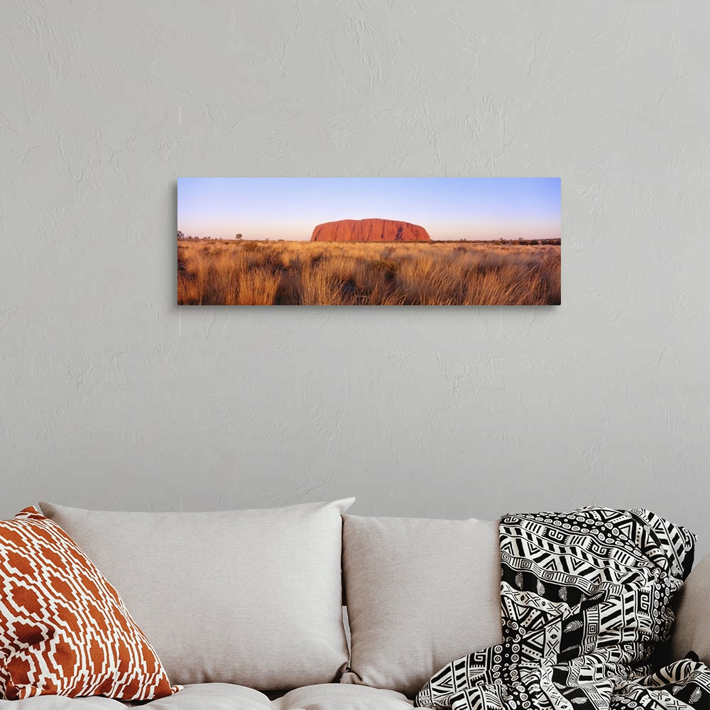 A bohemian room featuring Panoramic image of a famous geological formation in Australia.