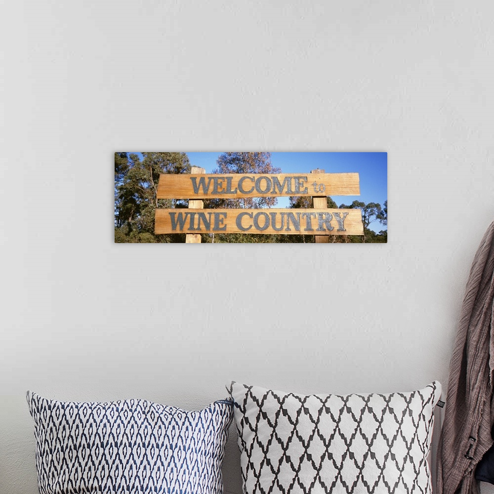A bohemian room featuring Panoramic photograph of wooden planks with text in front of a forest under a clear sky.