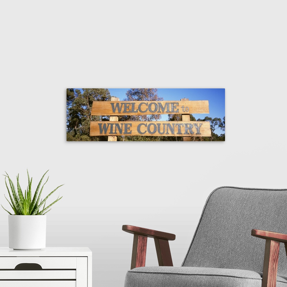 A modern room featuring Panoramic photograph of wooden planks with text in front of a forest under a clear sky.