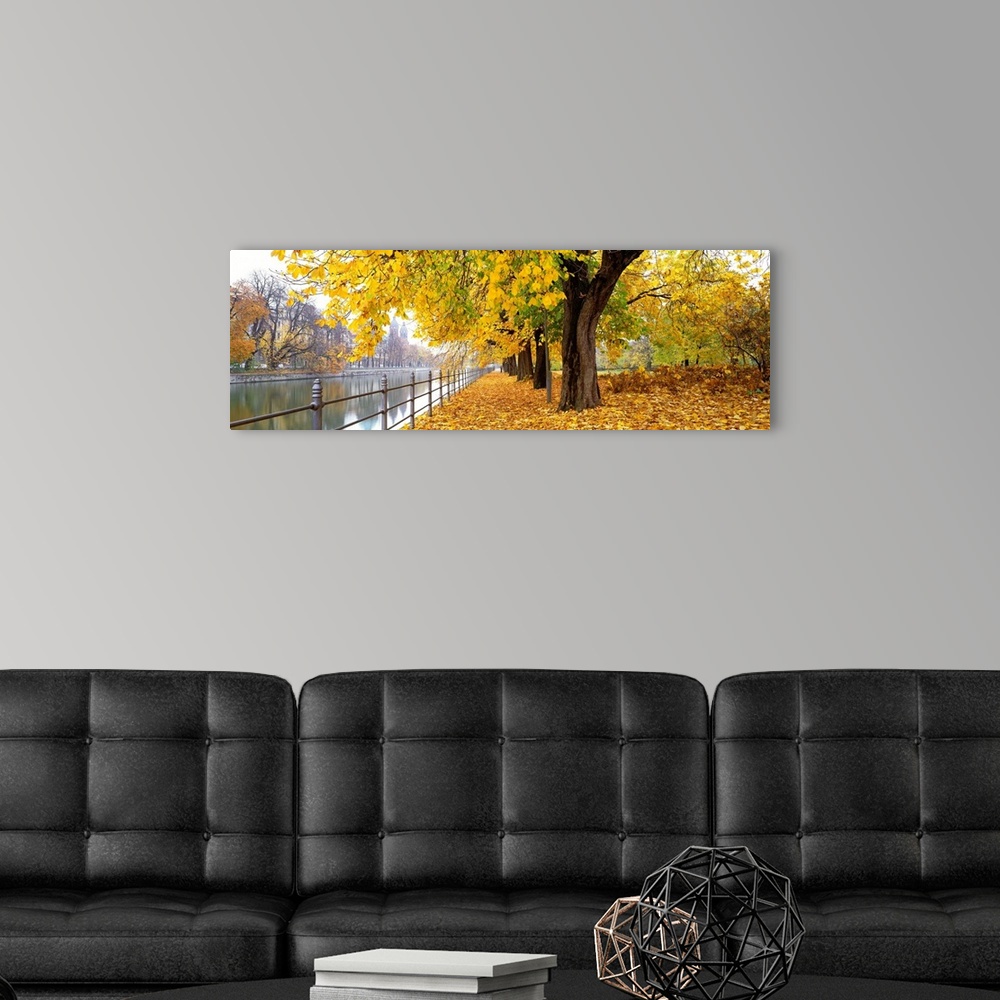 A modern room featuring Large panoramic photograph of city riverbank in Munich, Germany as fall/autumn turns to winter an...