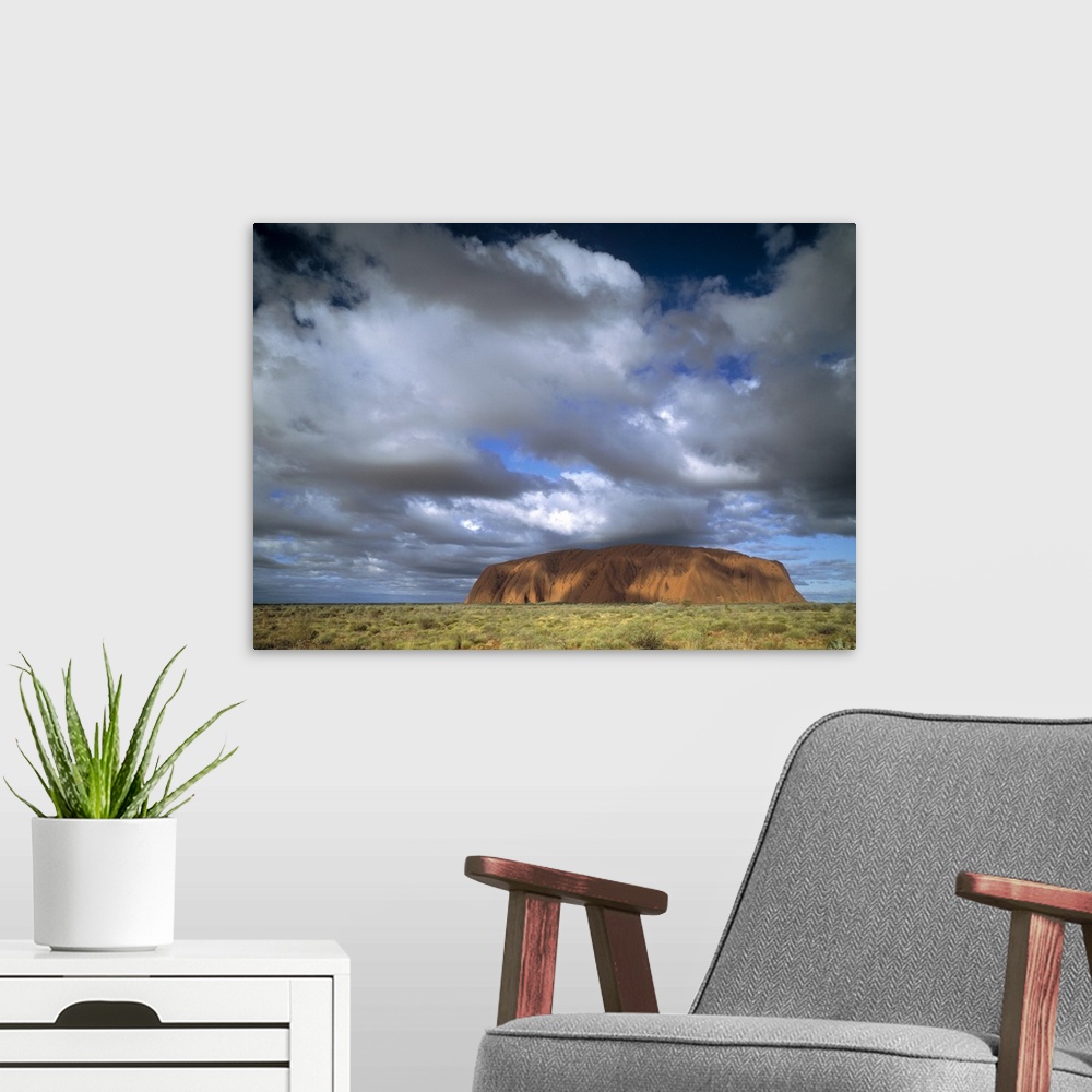A modern room featuring This is a landscape photograph of the mountain island landmark in the outback under growing cloud...