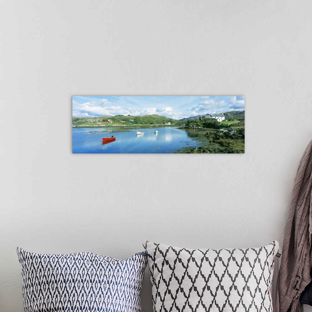A bohemian room featuring Panoramic photograph of canoes in the water with land and houses in the distance under a cloudy sky.