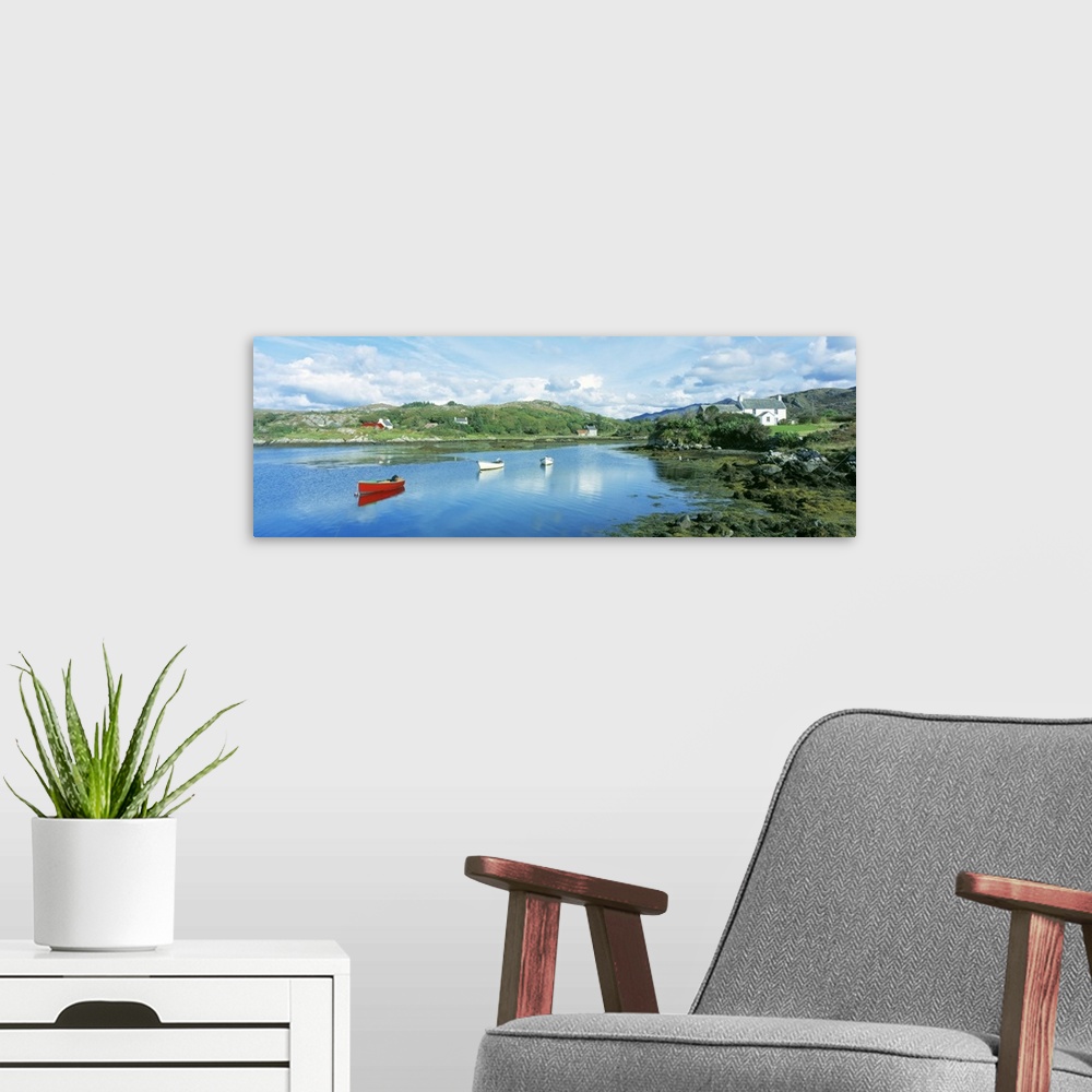 A modern room featuring Panoramic photograph of canoes in the water with land and houses in the distance under a cloudy sky.