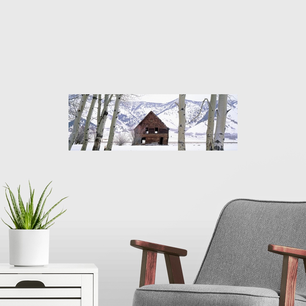 A modern room featuring This wall art is a panoramic photograph of decrepit barn in a snowy valley.