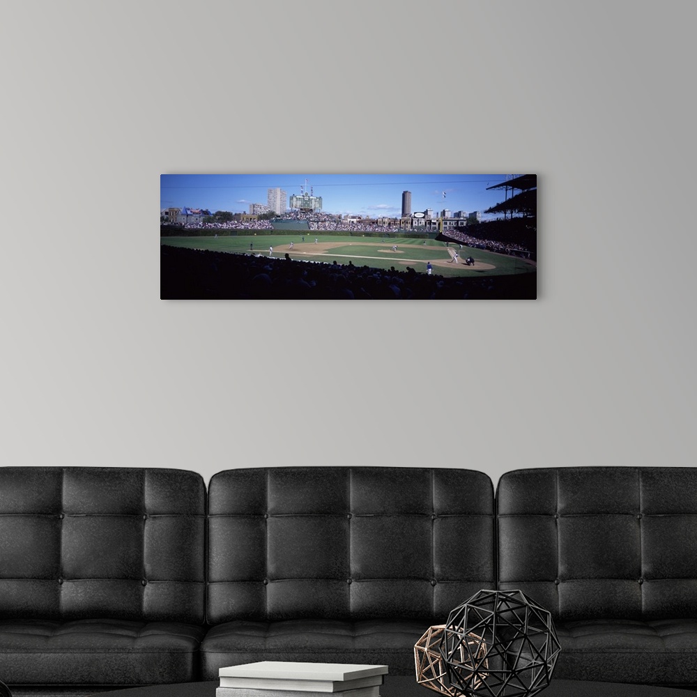 A modern room featuring Panoramic photo print of a professional baseball field with a game being played surrounded by spe...
