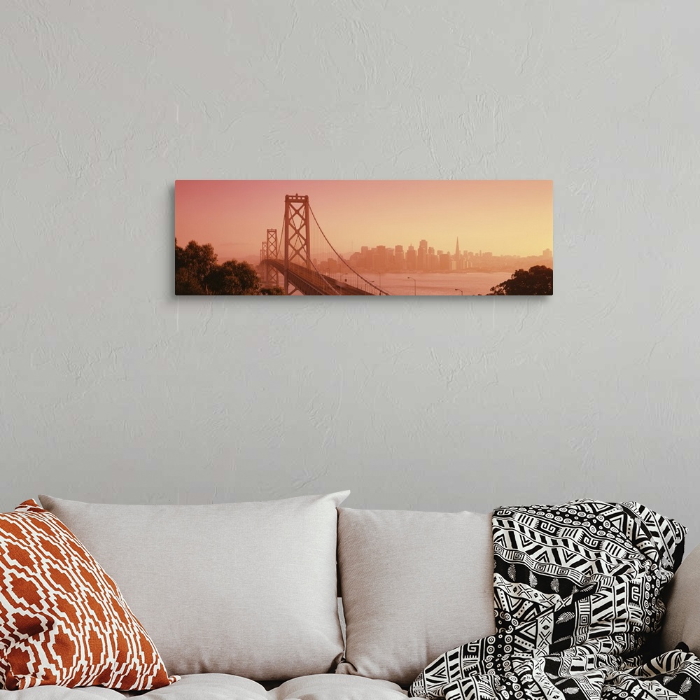 A bohemian room featuring Panoramic photograph of overpass crossing water with city skyline in the distance.